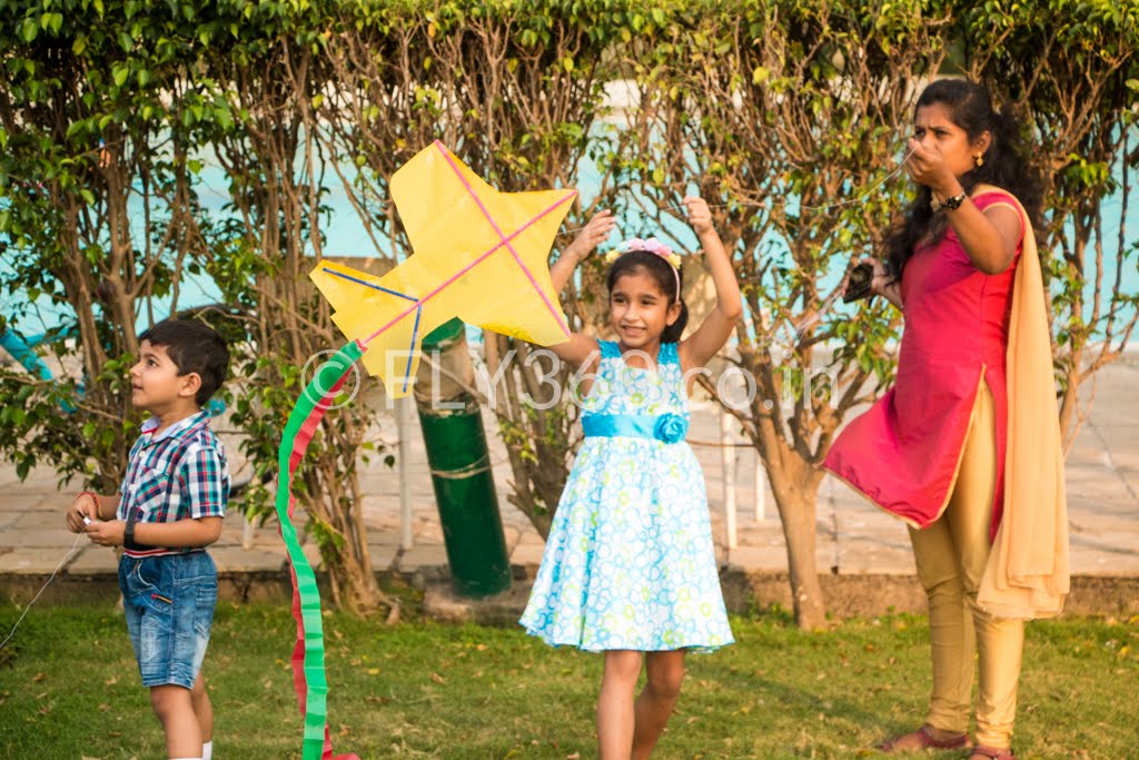 Children flying a star-shaped kite on a lawn during a Fly360 kite making workshop at a birthday party